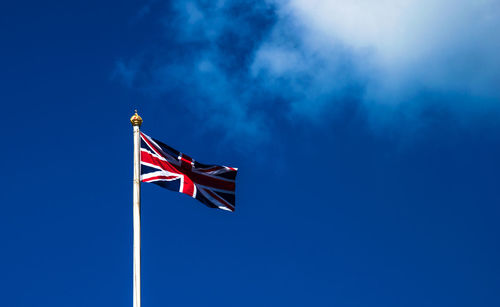 Low angle view of flag against blue sky