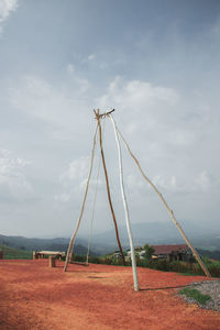 Electricity pylon on field against sky