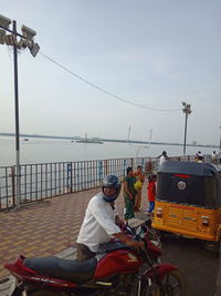 Man riding motorcycle in sea against sky