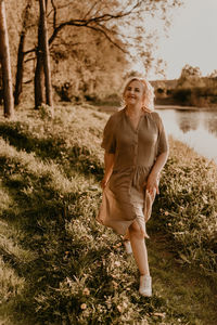 Portrait of young woman standing on field