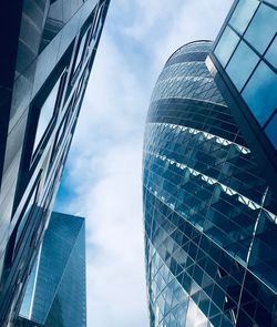 Low angle view of modern glass building against sky