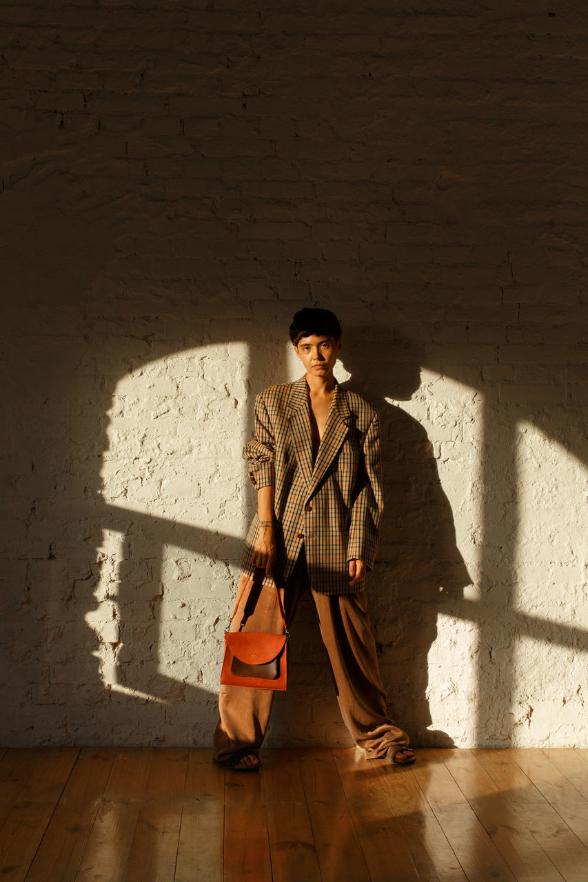 shadow, one person, full length, adult, sunlight, men, architecture, clothing, temple, wall - building feature, person, performance art, nature, front view, sitting, copy space