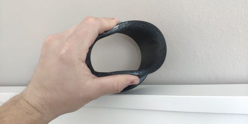 Close-up of person holding hand against wall