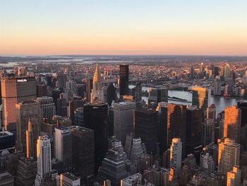 Aerial view of buildings in city against sky during sunset