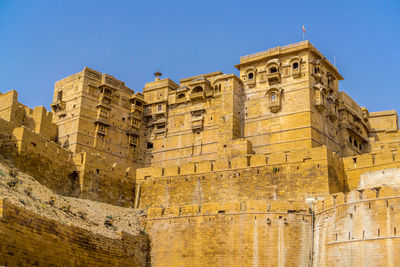 Low angle view of old building against blue sky