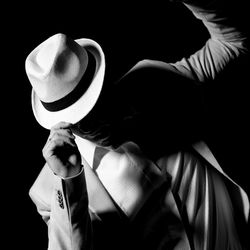Close-up of woman standing against black background