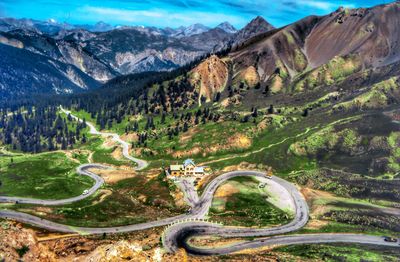 Scenic view of mountains against sky with winding hairpin roads 