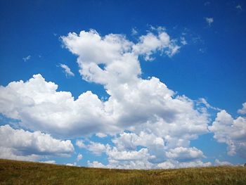 Scenic view of field against cloudy sky