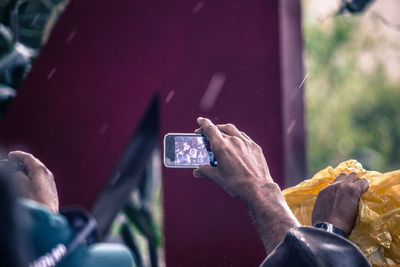 Close-up of man photographing with mobile phone