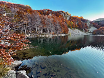 Lake santo reflections at sunset with autumn foliage, parma, italy