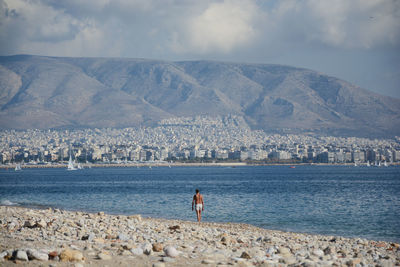 Rear view of man walking on shore at beach