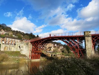 Arch bridge over river against sky