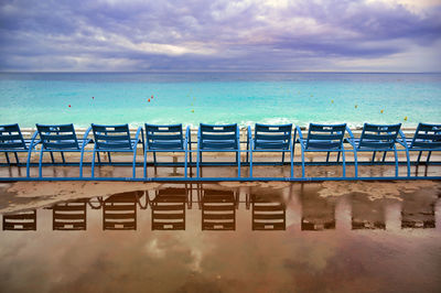 Chairs on beach against sky