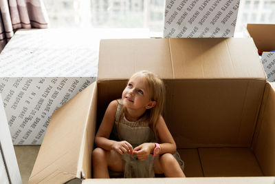 Cute girl sitting in box