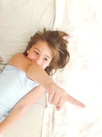 High angle portrait of young woman lying on bed at home