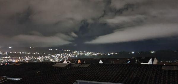 Illuminated buildings in city against sky at night