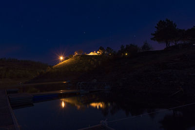 Scenic view of lake against sky at night