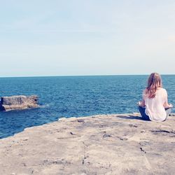 Rear view of woman sitting on beach