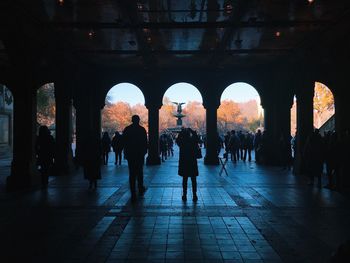 People walking in corridor of historical building