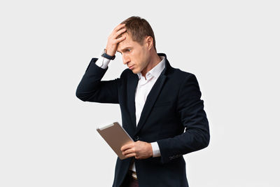 Young man using smart phone against white background