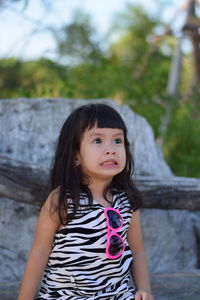 Portrait of smiling girl standing against tree