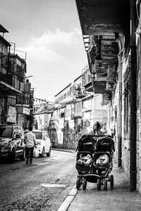 Rear view of people on street amidst buildings in city