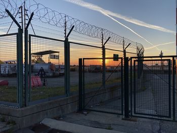 Fence against sky during sunset