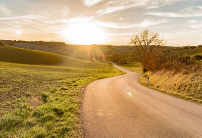 Road amidst landscape against dramatic sky