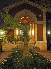 Illuminated street light by building at night