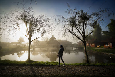 Woman standing by plants against sky