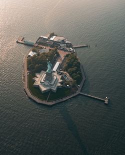 Statue of liberty on island amidst sea in city