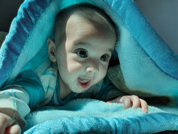 Portrait of cute boy lying on bed