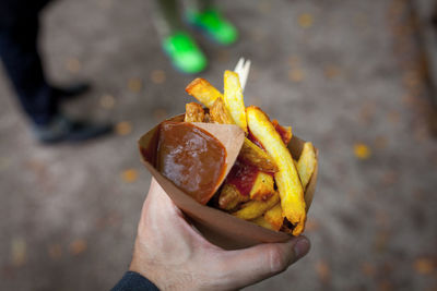 Cropped image of hand holding french fries