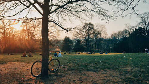 Bicycle and people watching a sunset in a park