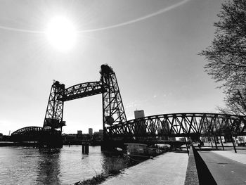 Low angle view of silhouette bridge against sky on sunny day