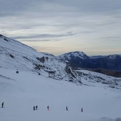 People skiing on snowcapped mountain against sky