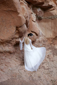 Rear view of woman standing in cave