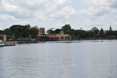 Scenic view of river by buildings against sky