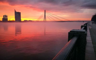 Bridge over river against sky during sunset