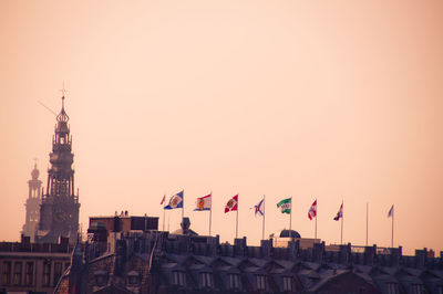 Flags on building against clear sky during sunset