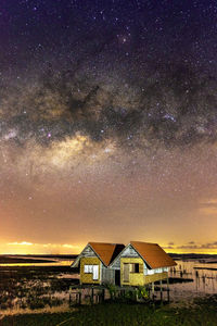 Houses and buildings against sky at night