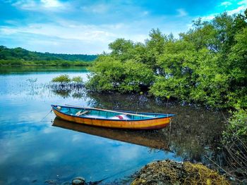 Boat moored in lake against sky