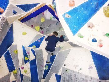 Rear view of boy climbing on boulder