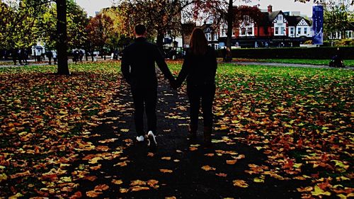 Rear view of two people walking outdoors