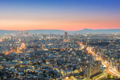 High angle view of illuminated cityscape against sky during sunset