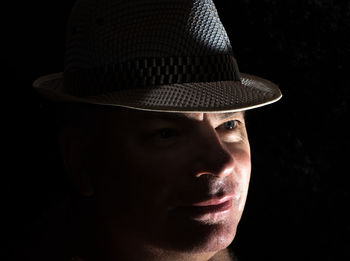 Close-up of man wearing hat in darkroom