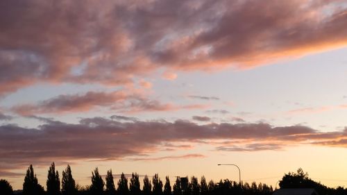 View of city against cloudy sky during sunset