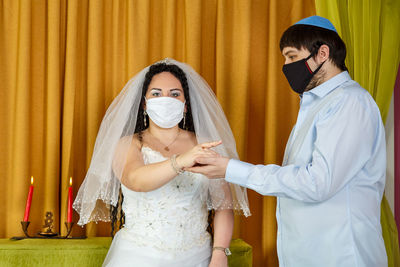 Young couple standing against curtain