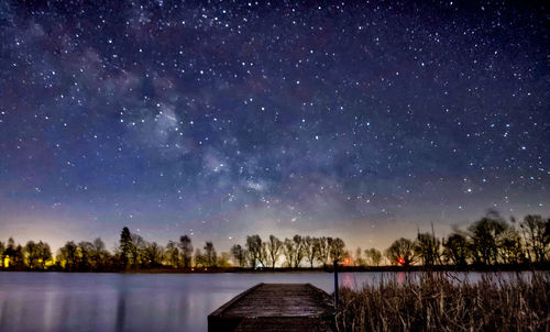 Scenic view of lake against sky at night