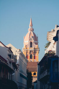 Low angle view of buildings against clear blue sky